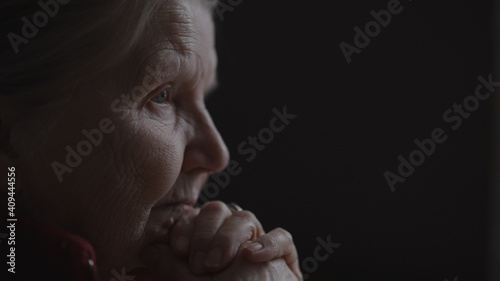 shot of old woman sitting near window and nods