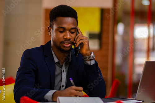 young handsome african businessman seriously taking notes about his business.