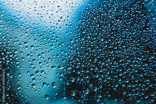 Water droplets background texture on window macro front view blue tint backlit