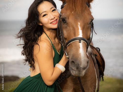 Portrait of happy smiling woman and brown horse. Asian woman hugging horse. Romantic concept. Love to animals. Nature concept. Selected focus. Bali