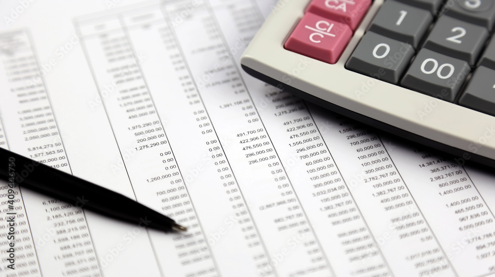 pen and calculator on financial data report pen and calculator on financial data report