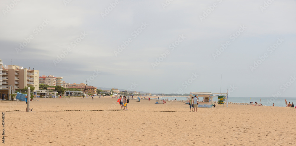Tourists walking and sunbathing on the beach Tourists walking and sunbathing on the beach