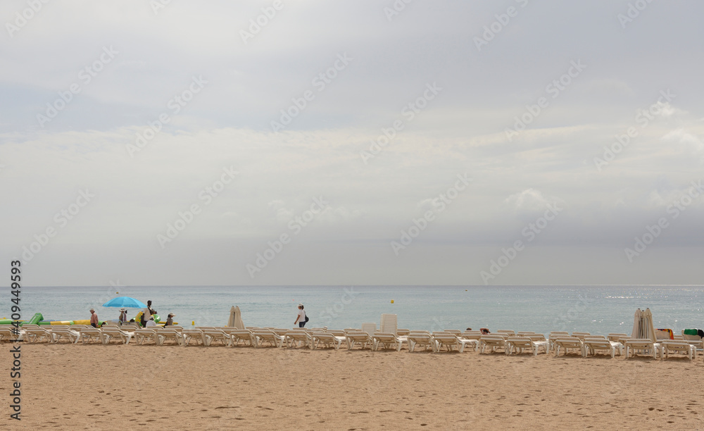 Tourists walking and sunbathing on the beach Tourists walking and sunbathing on the beach