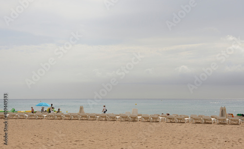  Tourists walking and sunbathing on the beach
