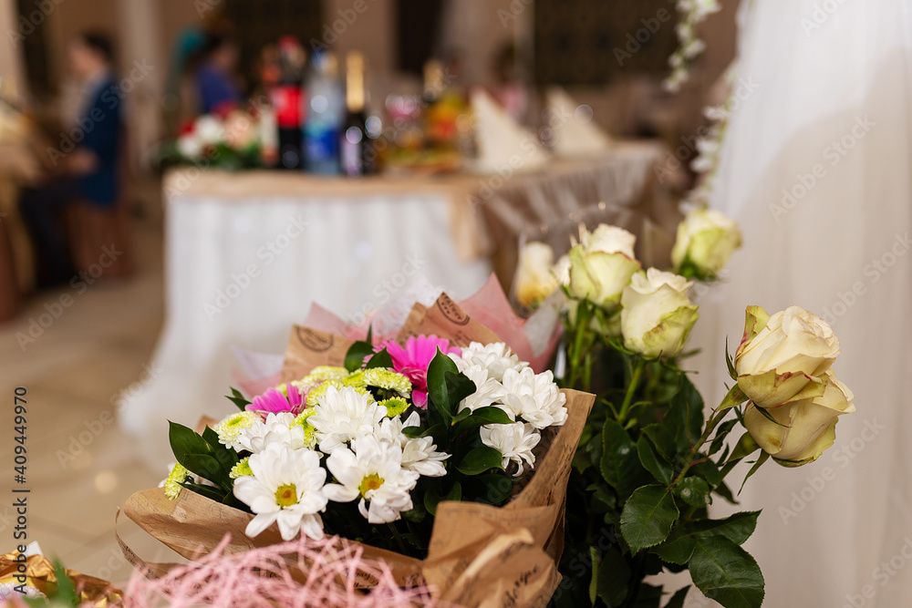 decorations with flowers at the wedding, the interior of the restaurant is prepared by the decorator for the holiday, beautiful fresh flowers in vases on the table, a bouquet as a gift from the guests decorations with flowers at the wedding, the interior of the restaurant is prepared by the decorator for the holiday, beautiful fresh flowers in vases on the table, a bouquet as a gift from the guests
