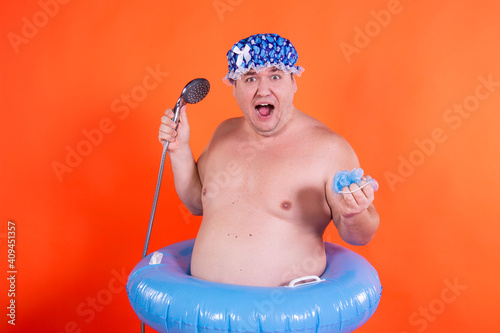 Funny fat man is washing in the shower.