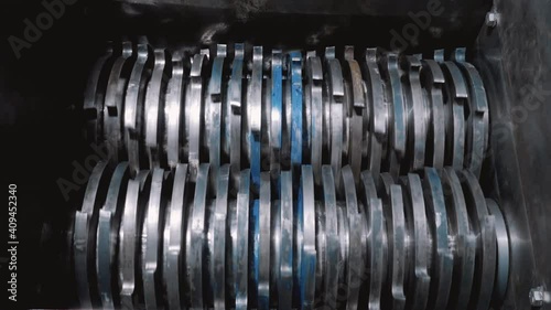 Rotation of gears for crushing debris. Steel cutters. raw material processing machine