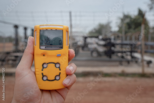 Action of a worker is using a portable gas detector device to testing the gas condition before entry to refinery plant. Safety action concept in the industrial.