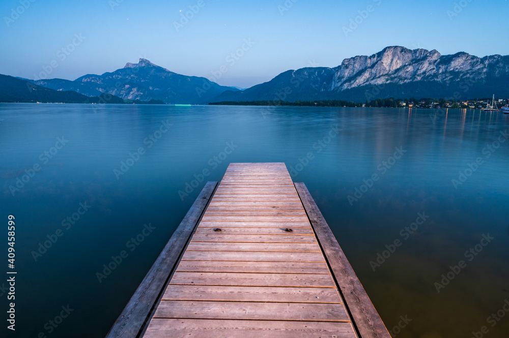 Wooden jetty at lake Mondsee near Salzburg during blue hour