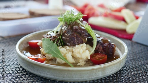 Venison and mashed potatoes with cherry tomatoes and herbs.