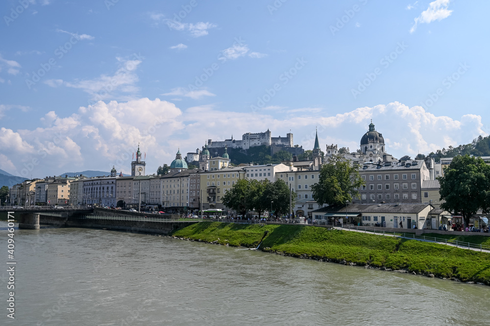 Castle Hohensalzburg on a hill and river Salzach in Salzburg on sunny day