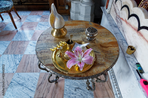 Puja lamp, flower, garland, conch, incense, water, handkerchief on a copper tray - hindu worship photo