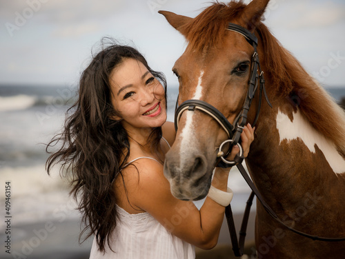 Portrait of Asian woman and brown horse. Woman hugging horse. Romantic concept. Human and animals relationship. Nature concept. Bali