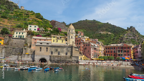 Italian National park, Parco Nazionale delle Cinque Terre, province of La Spezia, Liguria region, Italy. Amazing seashore of Vernazza with colorful houses, small boats and vineyards on mountain slopes
