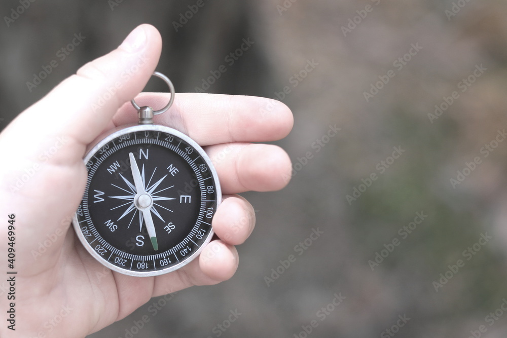 Old classic navigation compass in hand on natural background as symbol of tourism with compass, travel with compass and outdoor activities with compass Old classic navigation compass in hand on natural background as symbol of tourism with compass, travel with compass and outdoor activities with compass