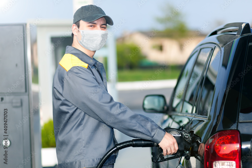 Gas station attendant at work while wearing a mask Gas station attendant at work while wearing a mask