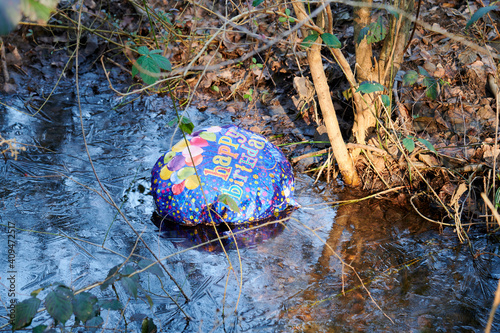 Luftballon eines Geburtstages landet als Umweltverschmutzung im Wald photo