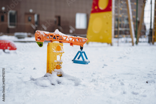 toy loading crane on playground in snow in winter