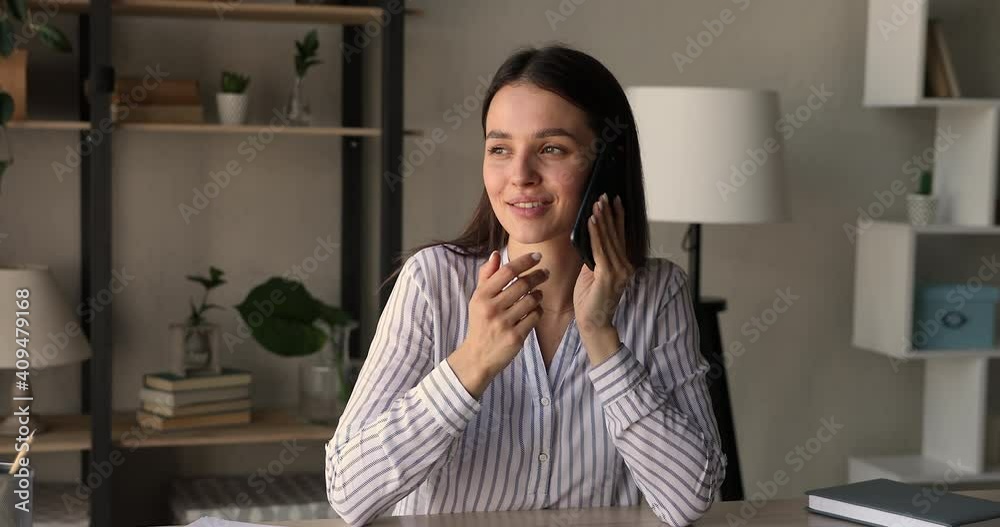 Happy young 25s woman involved in cellphone call conversation, talking speaking chatting with friends or communicating distantly with colleagues partners, discussing project issues at home office. Happy young 25s woman involved in cellphone call conversation, talking speaking chatting with friends or communicating distantly with colleagues partners, discussing project issues at home office.