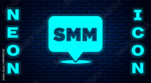 Glowing neon SMM icon isolated on brick wall background. Social media marketing, analysis, advertising strategy development. Vector.