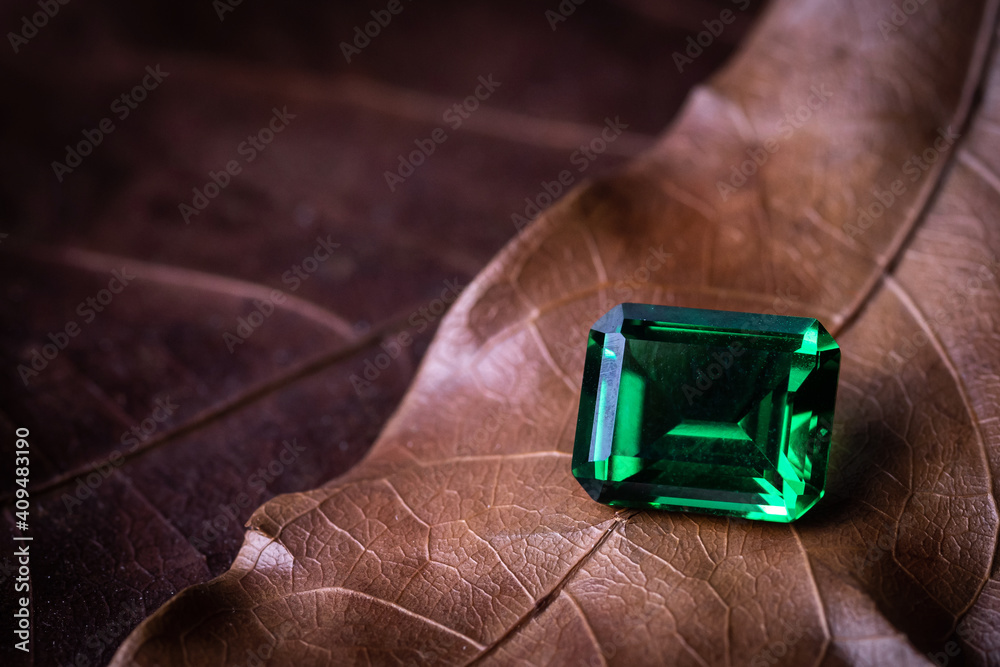 raw emeralds, gemstone jewelry on Dried leaves background raw emeralds, gemstone jewelry on Dried leaves background