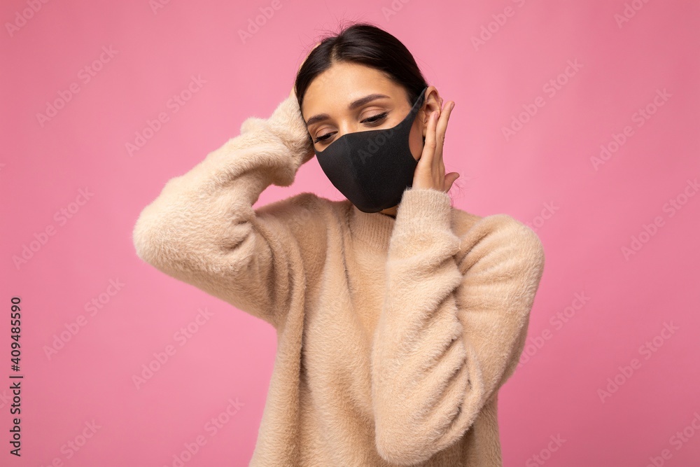Young woman wearing an anti virus protection mask to prevent others from corona COVID-19 and SARS cov 2 infection isolated over pink background Young woman wearing an anti virus protection mask to prevent others from corona COVID-19 and SARS cov 2 infection isolated over pink background