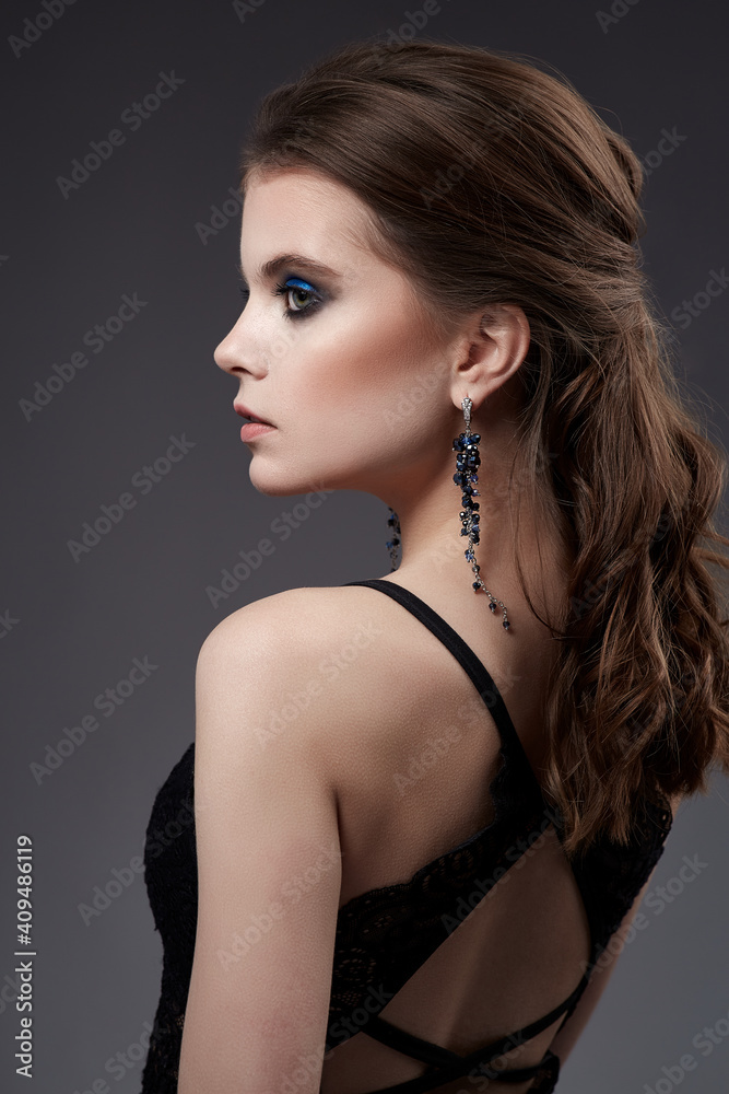 Beautiful woman portrait with earrings and black dress