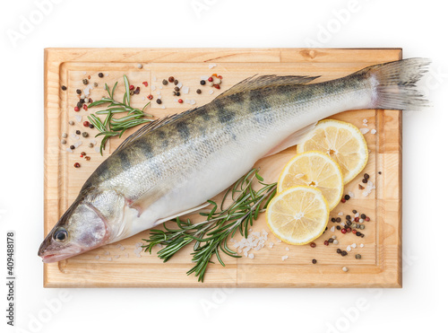 Foto Fresh uncooked pike perch with lemon, rosemary and spice on wooden board isolate
