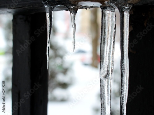 Icicles in Montreal, Canada, in North America during winter month of January on snowy weather. Transparent ice with sleek conic stalactite shape and slippery surface of frozen water.