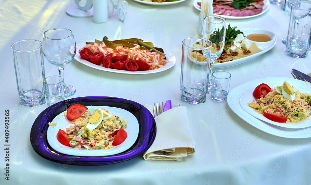 Decor and decoration of the festive table.Banquet table festive at the event in the restaurant. Wine glasses for wine. Plates with snacks. Fruit. A set festive table. The waitress.