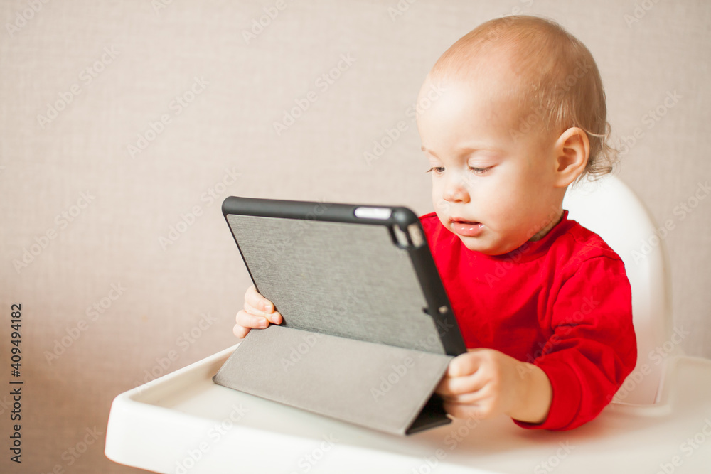 little girl with passion is watching an online educational program on a tablet. Watching cartoons. High quality photo little girl with passion is watching an online educational program on a tablet. Watching cartoons. High quality photo