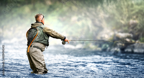 Fisherman hunting fish trouts in mountain river.