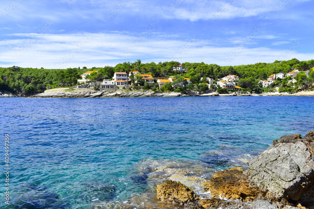 Beautiful Adriatic sea in Croatia in summer. Blue lagoon, houses in green pines, rocky coast. Mudri Dolac, Basina bay