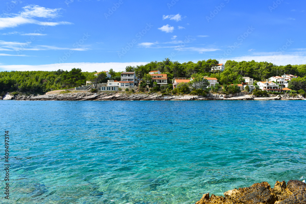 Beautiful Adriatic sea in Croatia in summer. Turquoise lagoon, houses in green pines, rocky coast.Mudri Dolac, Basina bay