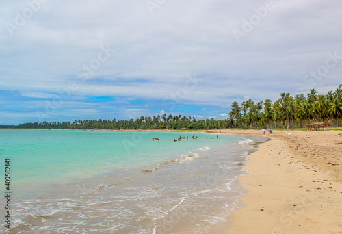 Praia com   gua cristalina e nuvens no c  u