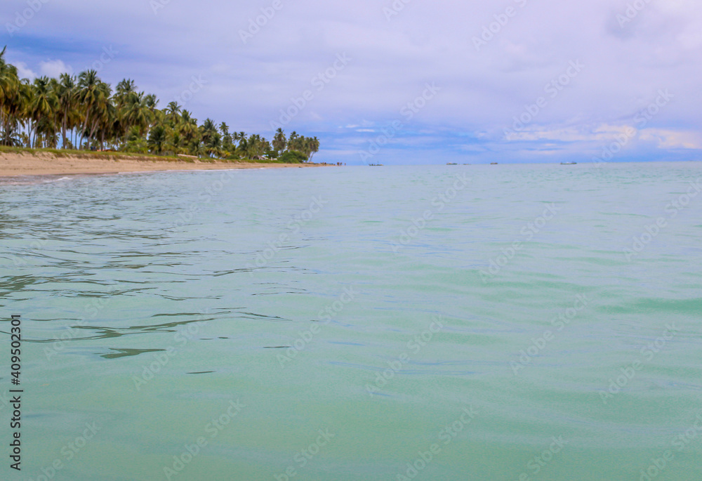 Praia com água cristalina e nuvens no céu Praia com água cristalina e nuvens no céu