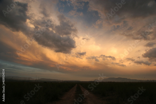 Atardecer con nubes y camino. Restos de tormenta. Cieza (Murcia-España).