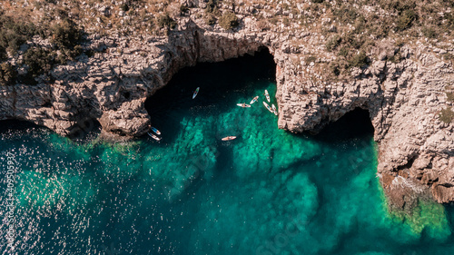 Beautiful rocky beach with SUP stand up paddle boards and with turquoise water in Montenegro. View from above with drone photo