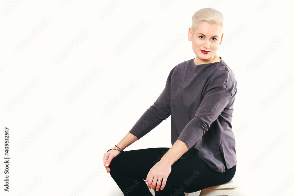 Studio portrait of mature woman posing on white background, sitting on ...