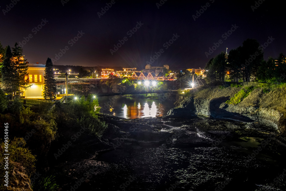 View of the Spokane Falls, river and dam from Riverfront Park in downtown Spokane, Washington at night.