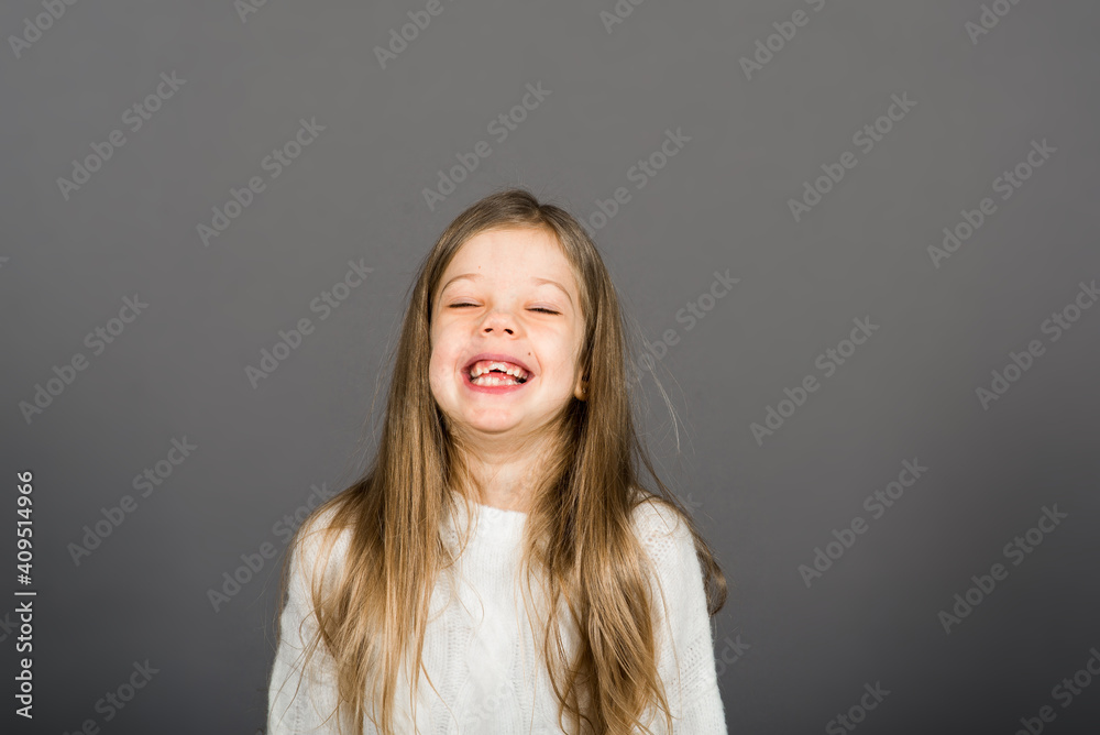 Portrait of a beautiful, joyful and confident girl isolated on grey