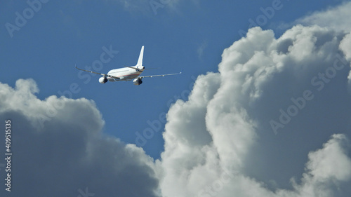 Zoom photo of passenger plane flying above deep blue cloudy sky © aerial-drone