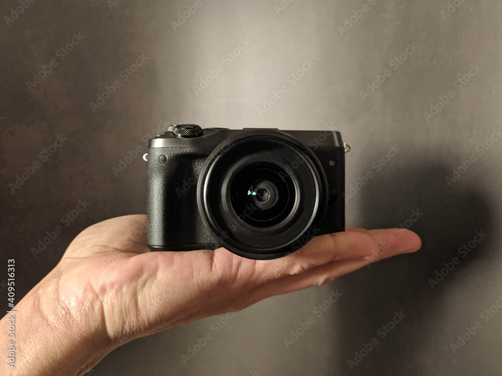 black photocamera in hand background