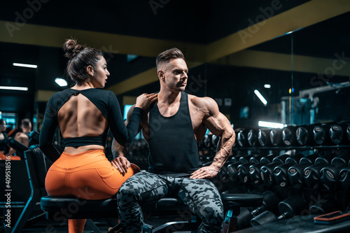 fitness couple of athletes or bodybuilders have workout and posing in gym