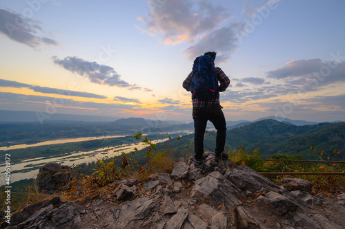 Rear view of man standing on the cliff to watch sunrise over mekong river in Nong Khai, Thailand