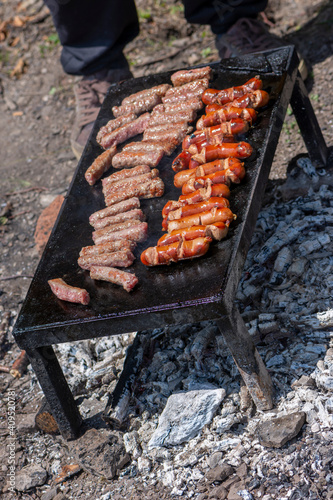 Grilling meat on bbq stone grill in nature photo