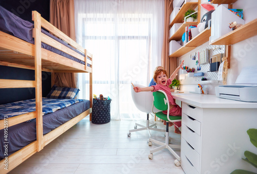 shared kids bedroom with bunk bed, big table and wall shelves, for two boys photo