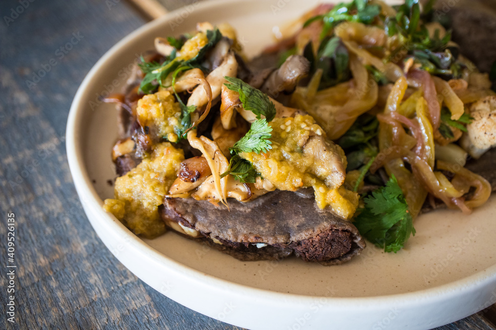 Vegan Mexican Food - featuring a cauliflower taco and a bean empanada topped with mushrooms Vegan Mexican Food - featuring a cauliflower taco and a bean empanada topped with mushrooms