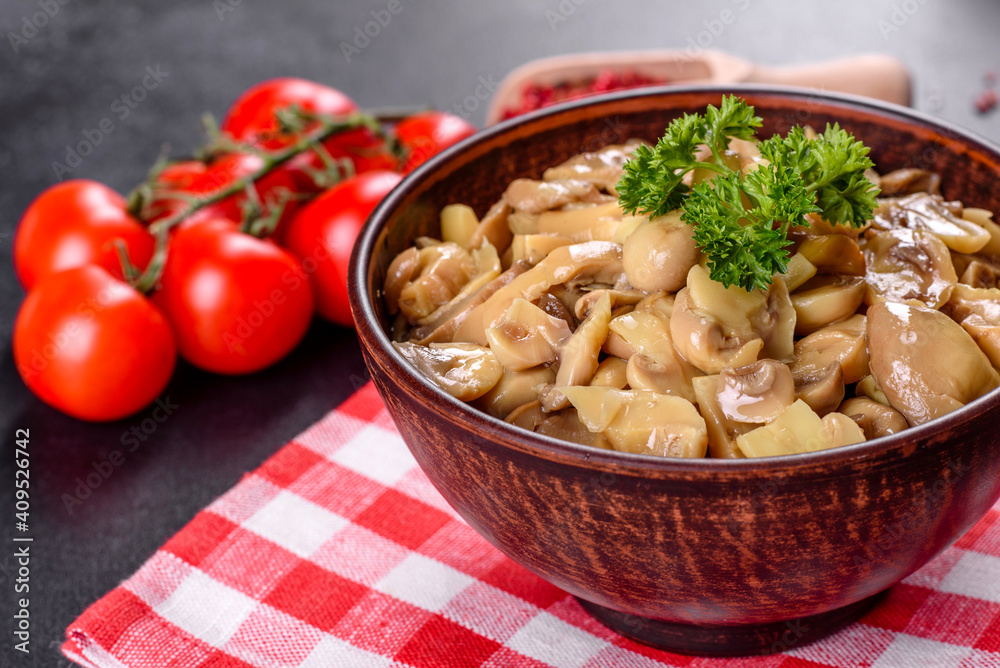 Fresh delicious spicy canned mushrooms with spices and herbs in ceramic dishes Fresh delicious spicy canned mushrooms with spices and herbs in ceramic dishes