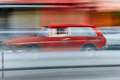 Car, model VW Volkswagen Variant color red, traveling at high speed, red and light blue trails, panning